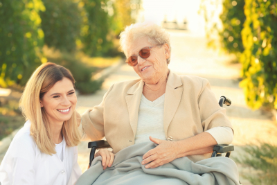 elder woman in wheelchair and nurse