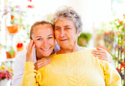 caregiver and senior woman are smiling together